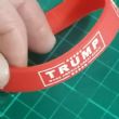 	Braccialetti silicone TRUMP . Braccialetti silicone TRUMP sono realizzati con lettere incise . Braccialetti silicone TRUMP sono fatti per allungarsi sulla mano per adattarsi al polso colore rosso .